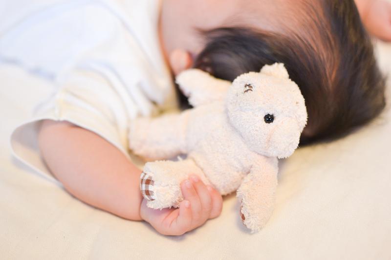 ぬいぐるみを握る赤ちゃん