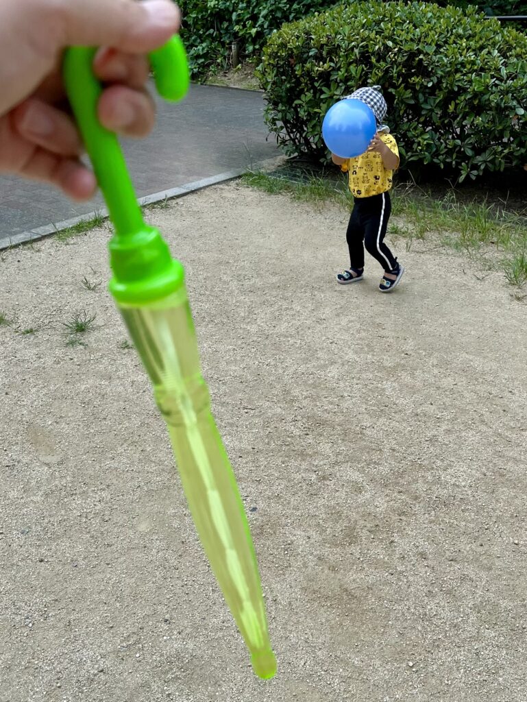 傘型シャボン玉スティックとボールを持つ息子